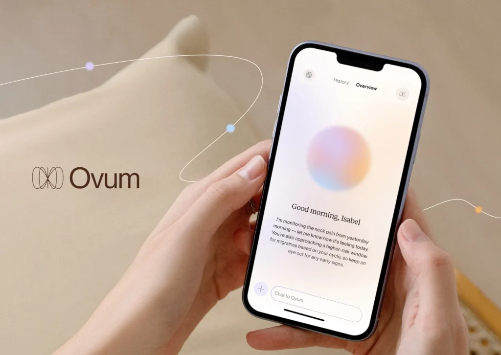 Mãos seguram celular exibindo o aplicativo de saúde Ovum, ao lado do logo da marca