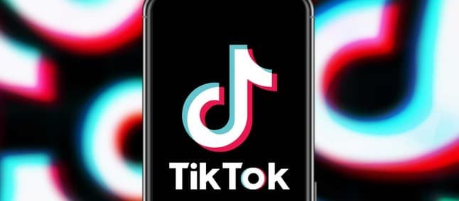 Celular exibindo o logo do TikTok em fundo desfocado com o ícone repetido