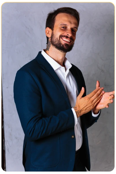 Douglas Gomides sorridente, batendo palmas, de terno azul-marinho