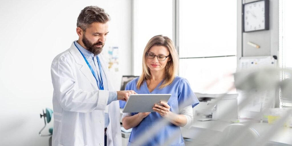 Médico e enfermeira analisam informações juntos em um tablet