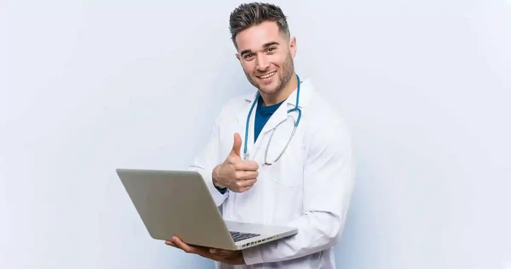 Médico sorridente com notebook faz sinal de positivo com o polegar