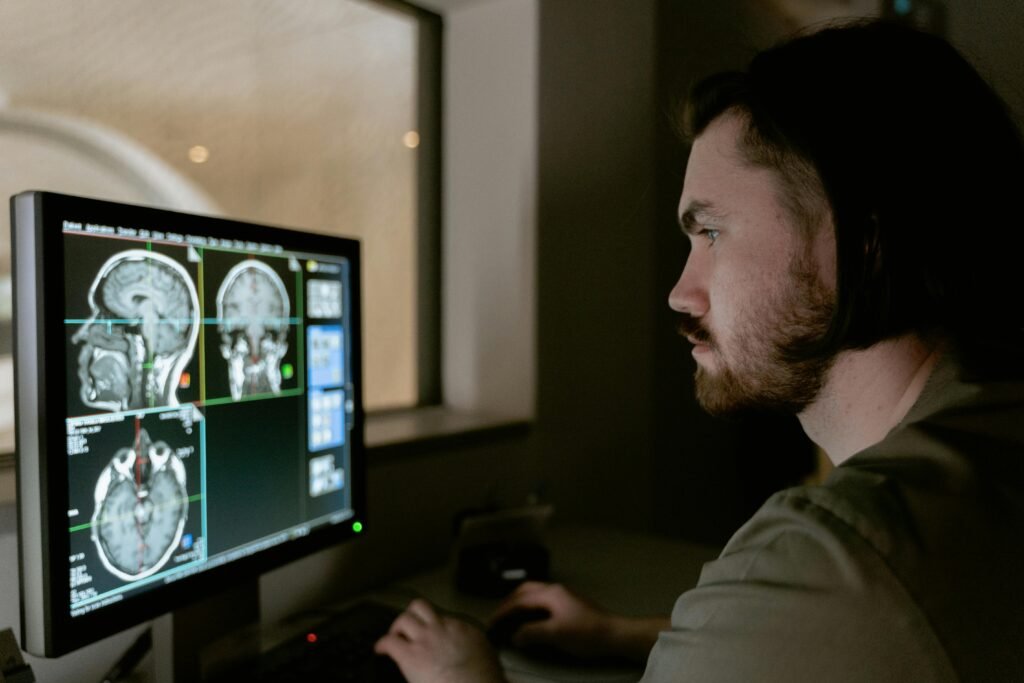 Homem analisa exames de ressonância magnética do cérebro em monitor