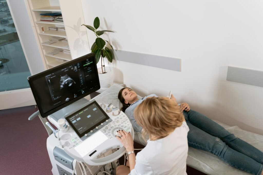 Médica realiza ultrassom em paciente deitada, com imagem do exame na tela ao lado