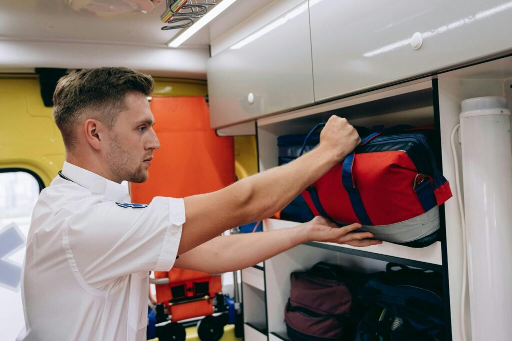 Paramédico organiza mochila de emergência em compartimento de ambulância