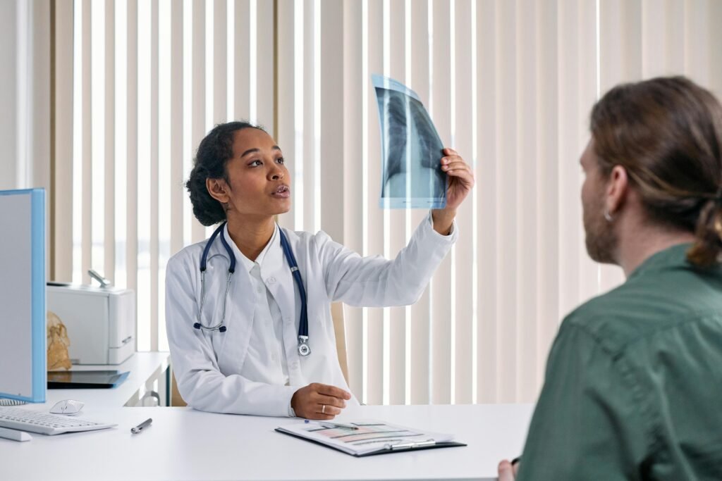 Médica de jaleco branco mostra radiografia de pulmão a paciente em consultório