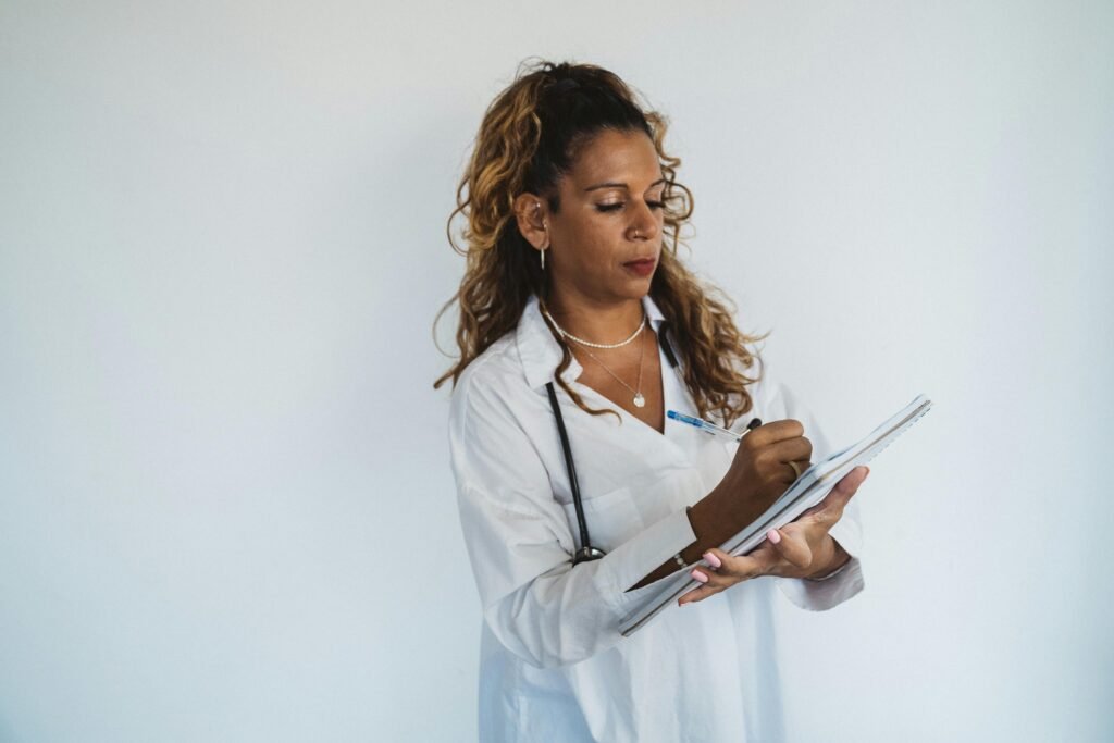 Médica de jaleco branco faz anotações em bloco de notas