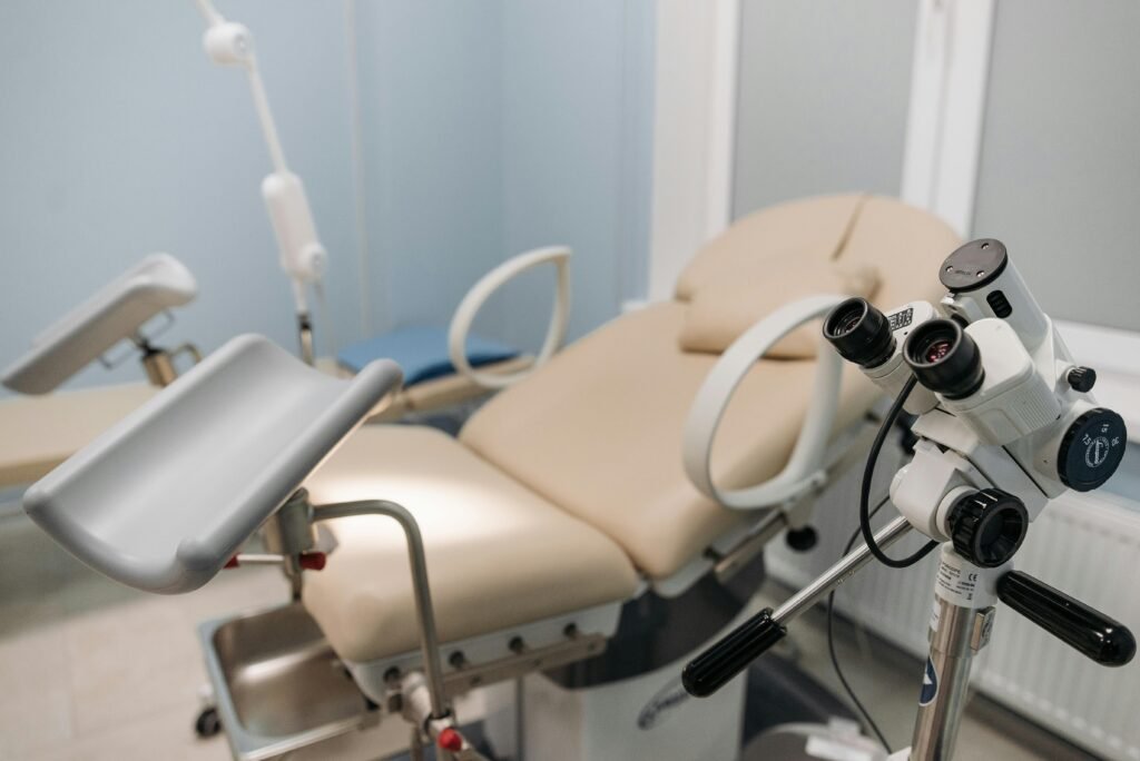 Mesa ginecológica de exame com colposcópio em consultório