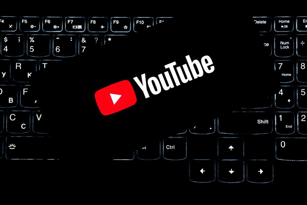 Logo do YouTube iluminado sobre teclado retroiluminado de notebook