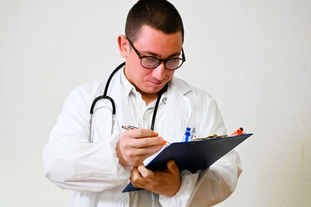 Médico de óculos e estetoscópio faz anotações em prancheta